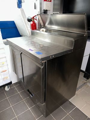 un plan de travail en acier inoxydable dans une cuisine équipée d'un extincteur