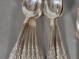three silver spoons and two silver spoons on a table