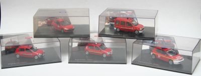 six petites voitures rouges dans des boîtes transparentes, posées sur une surface blanche