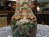 a vase that is sitting on a table with a lamp on it