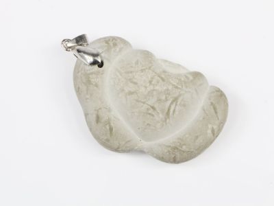 pendentif en jade blanc muni d'un fermoir en argent, sur fond blanc