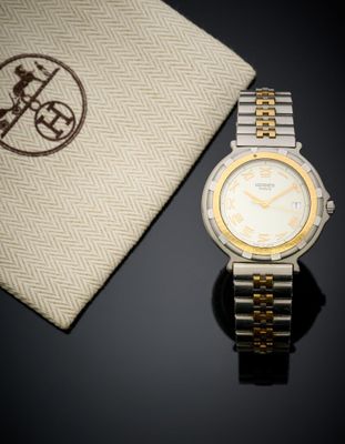 a watch sitting next to a bag on a table