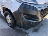 a close up of the front of a van with a denting on it