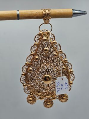 un gros plan sur une paire de boucles d'oreilles suspendues à un bâtonnet en bois