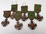 un ensemble composé de quatre médailles et d'une croix sur un fond blanc