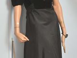 un mannequin vêtu d'une robe noire et d'un chapeau