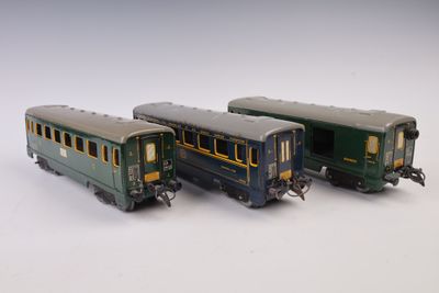trois petits trains assis l'un à côté de l'autre sur une surface blanche