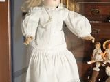 a display case with a doll in it that has many dolls inside of it