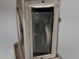 a small silver clock with a picture in it
