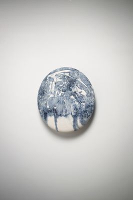 une photo d'un objet bleu et blanc posé sur une surface blanche