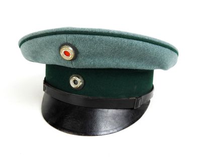 un chapeau vert orné d'un bouton rouge