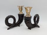 pair of black and gold candlesticks with horns on them