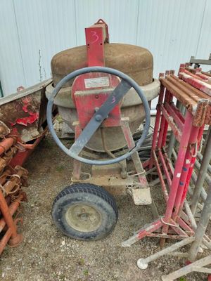 a picture of a wheel and some pipes in a yard
