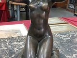 une statue de femme assise sur une table