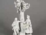 figurine of a man and a woman with a basket of flowers