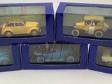 six petites voitures miniatures se trouvent dans une boîte bleue posée sur une surface blanche