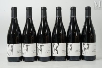 six bouteilles de vin sont alignées sur une table