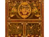 an ornately decorated chest of drawers with flowers and birds on it
