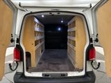 a small white van with its doors open in a garage
