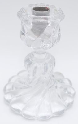 clear glass candle holder on a white surface with a black candle
