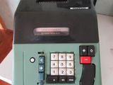 une machine à écrire verte posée sur une table blanche