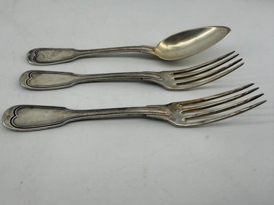 three forks and a spoon are sitting on a table
