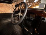 steering wheel and dashboard of an old car with a brick wall in the background