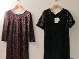 deux robes pour femmes suspendues à un mur à l'aide de cintres