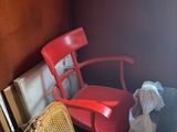 une chaise rouge placée dans un coin de la pièce, près d'une fenêtre
