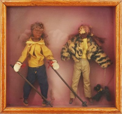 two dolls in a shadow box with a dog on a leash