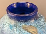 a large blue vase with a fish design on it