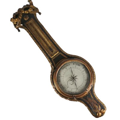 Une vieille horloge ornée d'un oiseau est accrochée au mur.