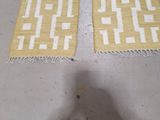 pair of yellow and white rugs sitting on top of a white floor