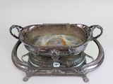 a silver plate with a bowl on it on a stand