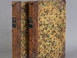 an old book sitting on top of a table next to a gray wall