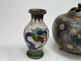 two vases sitting next to each other on a white surface