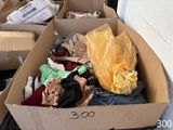 une boîte en carton remplie de vêtements posée par terre