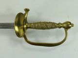 a gold sword with a handle on a white surface
