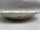 a white bowl with orange and blue designs on it