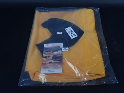 un t-shirt jaune et un chapeau noir dans un sac en plastique