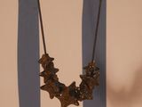 un collier accroché à un mur, avec en arrière-plan un mur rayé de bleu et de blanc