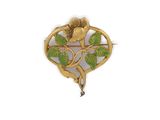 a close up of a gold brooch with a flower on it