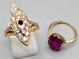 two rings and a ring with a ruby stone on a white surface