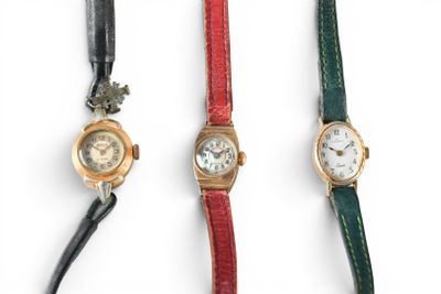 three different colored watches are lined up on a white surface