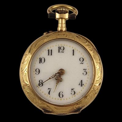 a close up of a gold pocket watch on a black background