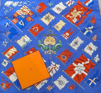 un gros plan sur une écharpe bleue sur laquelle figure une boîte orange