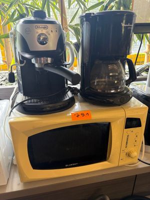two coffee makers on top of a microwave on a counter