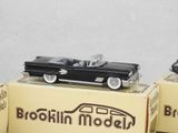 two model cars sitting on top of boxes on a table