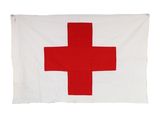 a red cross flag hanging on a white wall