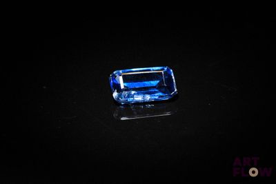 a blue sapphire stone on a black surface